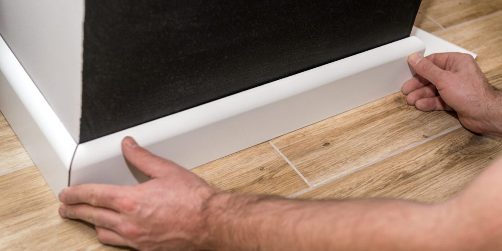 Close,Up,Of,Mans,Hands,Installing,Skirting,Board